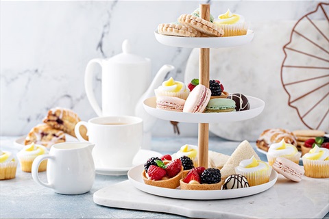 Hight tea stand with biscuits, sandwiches and cakes